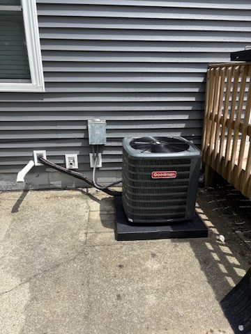 A Goodman AC condenser installed beside a patio with tidy line-set routing at a Niles, MI area home