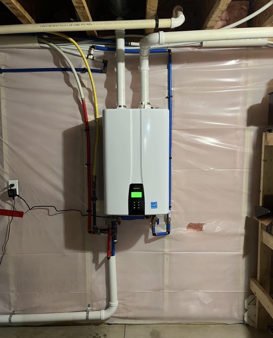 New Navien tankless water heater mounted on the wall with clean PEX water lines in a Niles, MI area basement